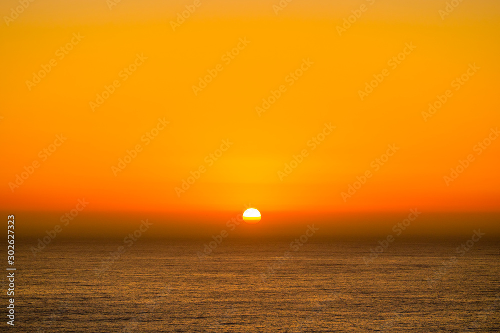 Beautiful and peaceful golden sunset or sunrise over the ocean.