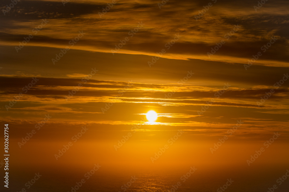 Beautiful and peaceful golden sunset or sunrise over the ocean.