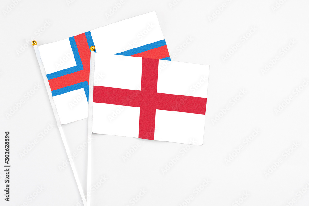 England and Faroe Islands stick flags on white background. High quality fabric, miniature national flag. Peaceful global concept.White floor for copy space.