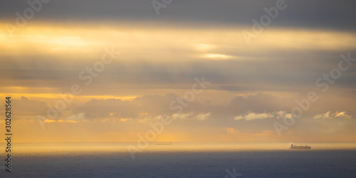 Fototapeta Naklejka Na Ścianę i Meble -  Fishing ships on a golden blue ocean sunset or sunrise in Cape Town.