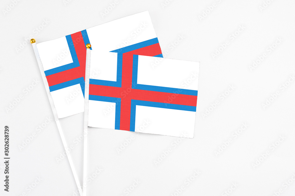 Faroe Islands and Faroe Islands stick flags on white background. High quality fabric, miniature national flag. Peaceful global concept.White floor for copy space.