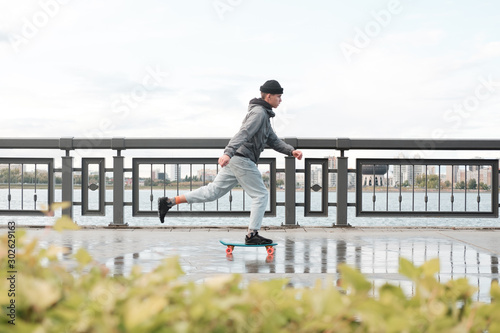 young teenager rides on a penny board starting from the foot. 