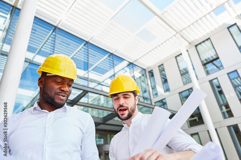 Two architects or construction manager with blueprint Two architects or construction manager with blueprint