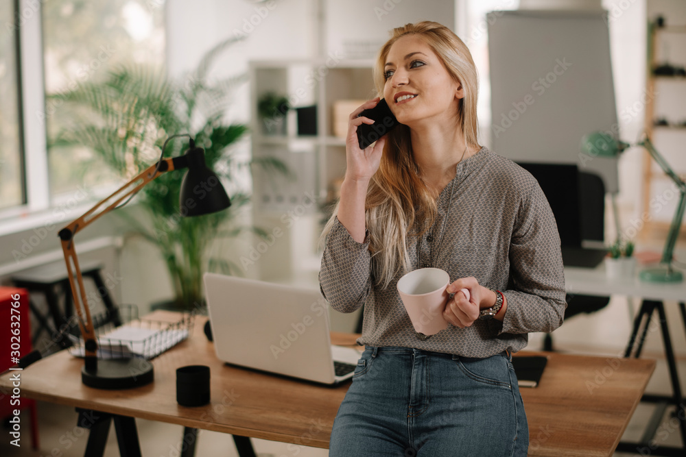 Businesswoman talking on mobile phone in office. 