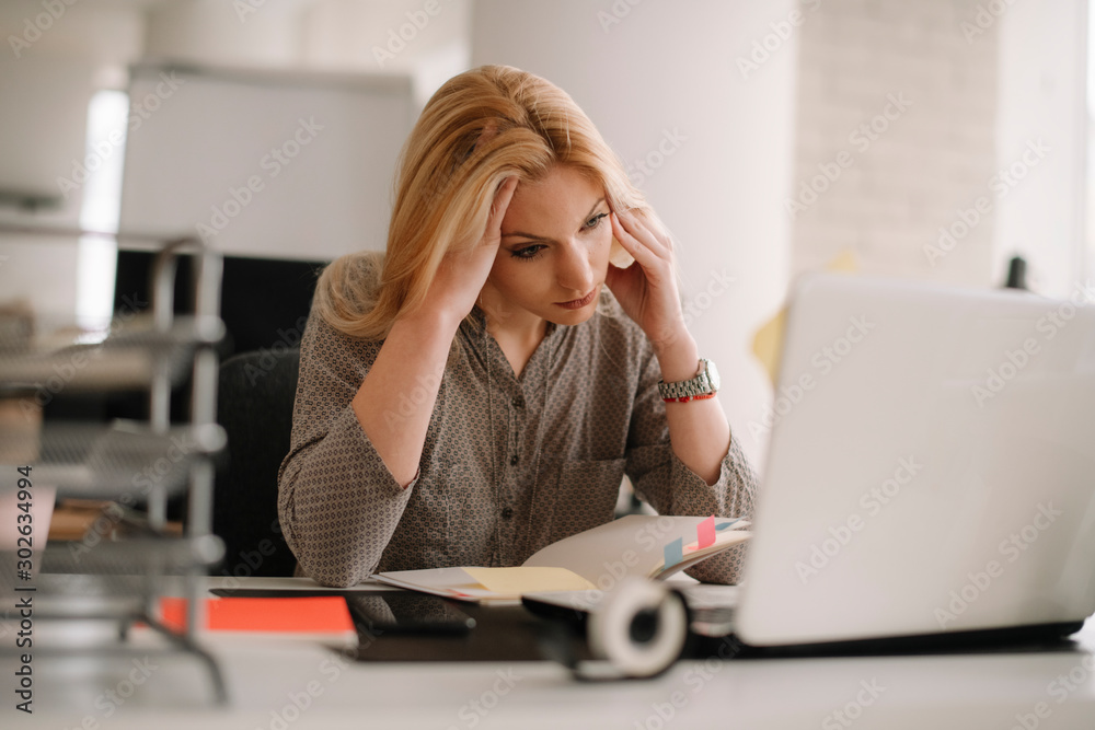 Young tired businesswoman in the office. Beautiful woman sitting in office having headache. Young tired businesswoman in the office. Beautiful woman sitting in office having headache.