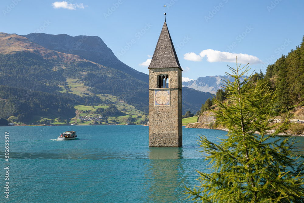 The bell tower submerged by the water in the Resia lake. Alps, Italy.