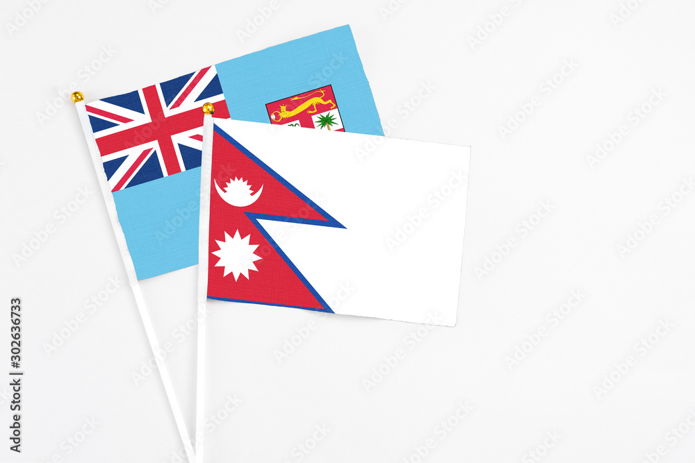 Nepal and Fiji stick flags on white background. High quality fabric, miniature national flag. Peaceful global concept.White floor for copy space. Nepal and Fiji stick flags on white background. High quality fabric, miniature national flag. Peaceful global concept.White floor for copy space.