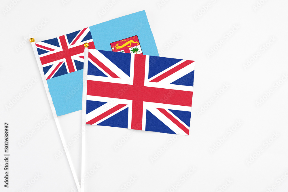 United Kingdom and Fiji stick flags on white background. High quality fabric, miniature national flag. Peaceful global concept.White floor for copy space. United Kingdom and Fiji stick flags on white background. High quality fabric, miniature national flag. Peaceful global concept.White floor for copy space.