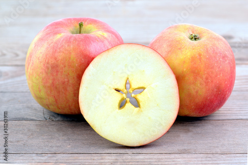 Christmas motive - cross section of  apple with star, two apples on wooden background. 