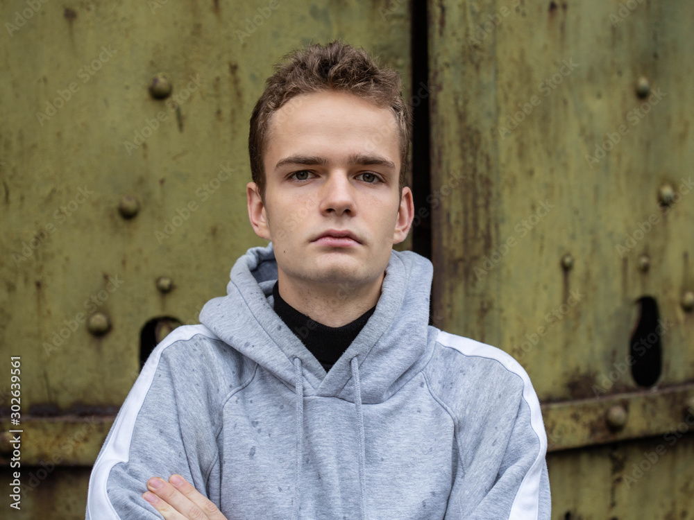 portrait of a stressful lonely teenager in a hoody on a wall background, concept of teenagers problems portrait of a stressful lonely teenager in a hoody on a wall background, concept of teenagers problems