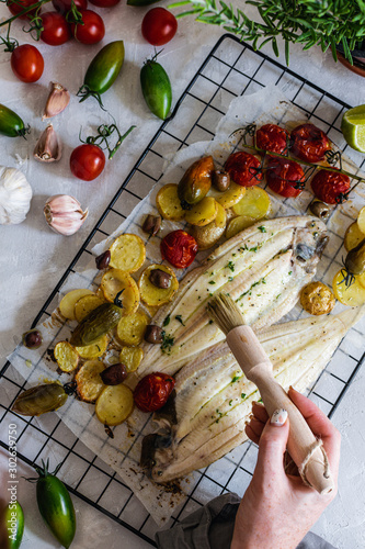 Grilled sole fish with green and red cherry tomatos, potatoe, capers, garlic, parsley and olive oil