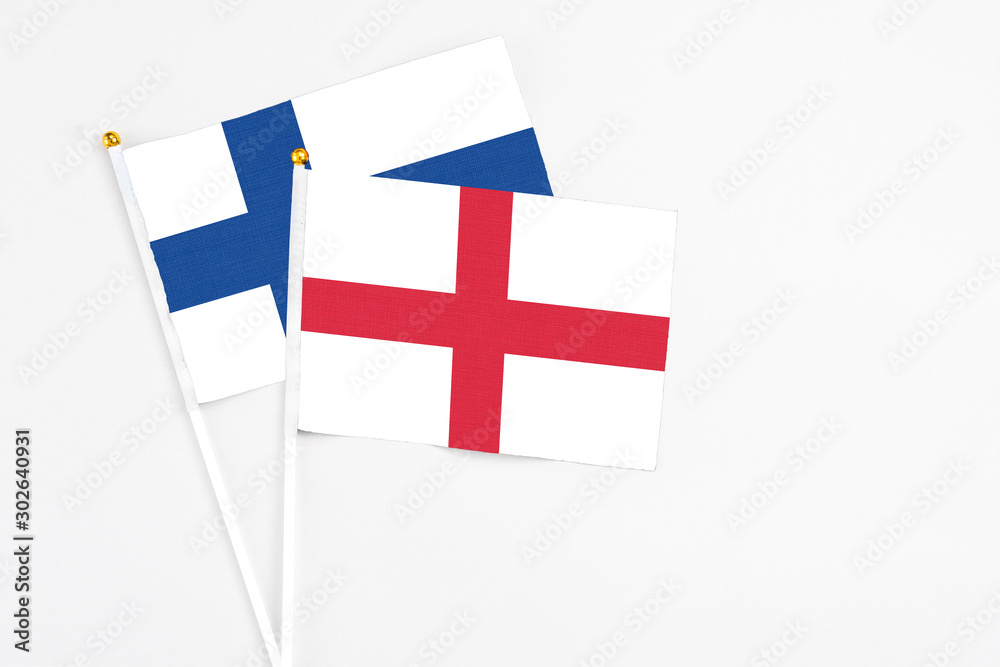 England and Finland stick flags on white background. High quality fabric, miniature national flag. Peaceful global concept.White floor for copy space.