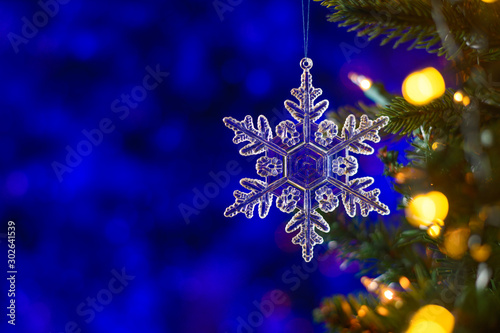 Christmas toy star on a Christmas tree, with a beautiful bright bokeh. Background for cards and congratulations © Anton