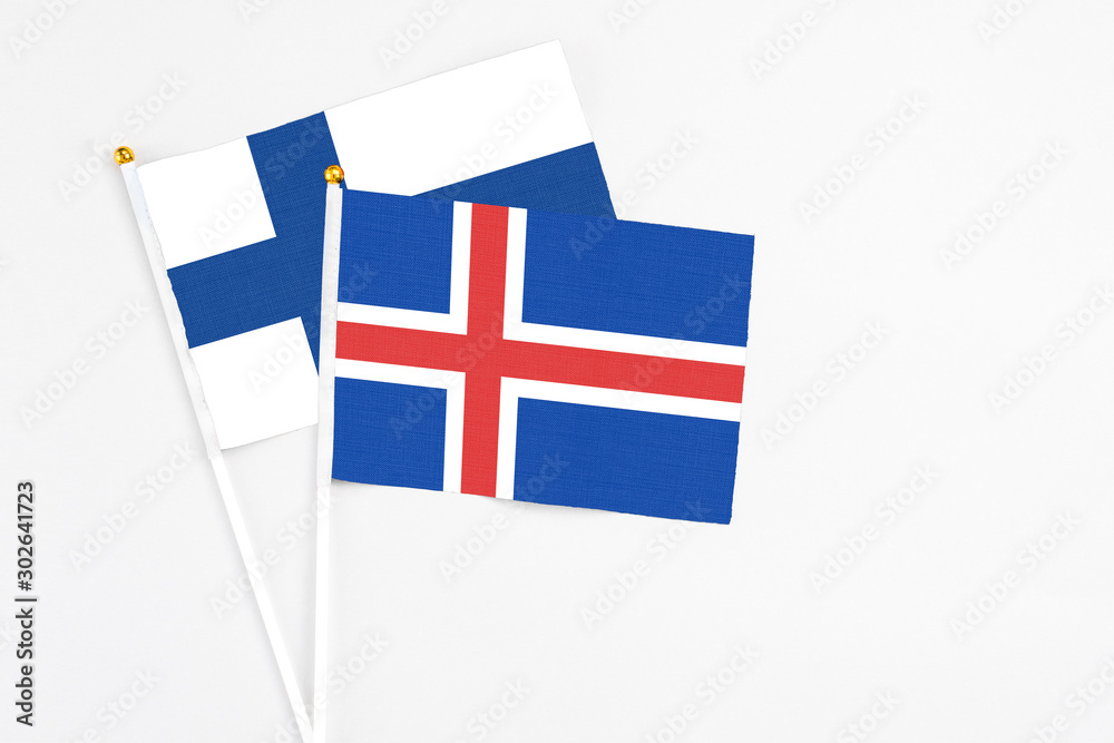 Iceland and Finland stick flags on white background. High quality fabric, miniature national flag. Peaceful global concept.White floor for copy space.