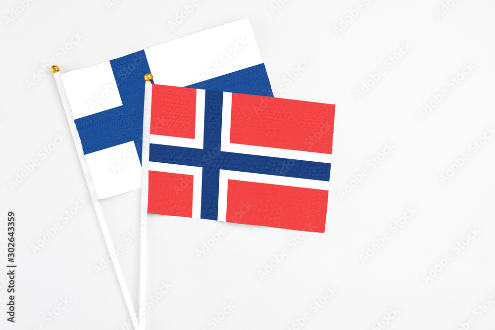 Norway and Finland stick flags on white background. High quality fabric, miniature national flag. Peaceful global concept.White floor for copy space.