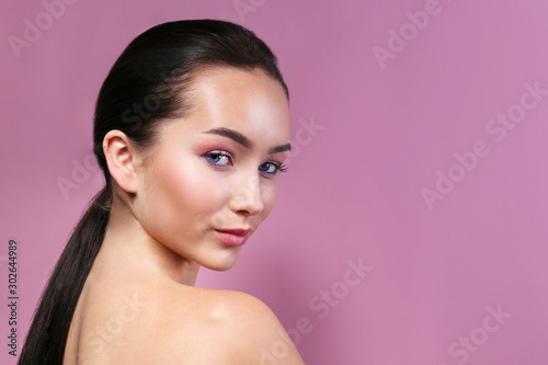 Portrait of young beautiful woman with perfectly clean face skin wearing professional make up. Female with long black hair. Close up, copy space background.