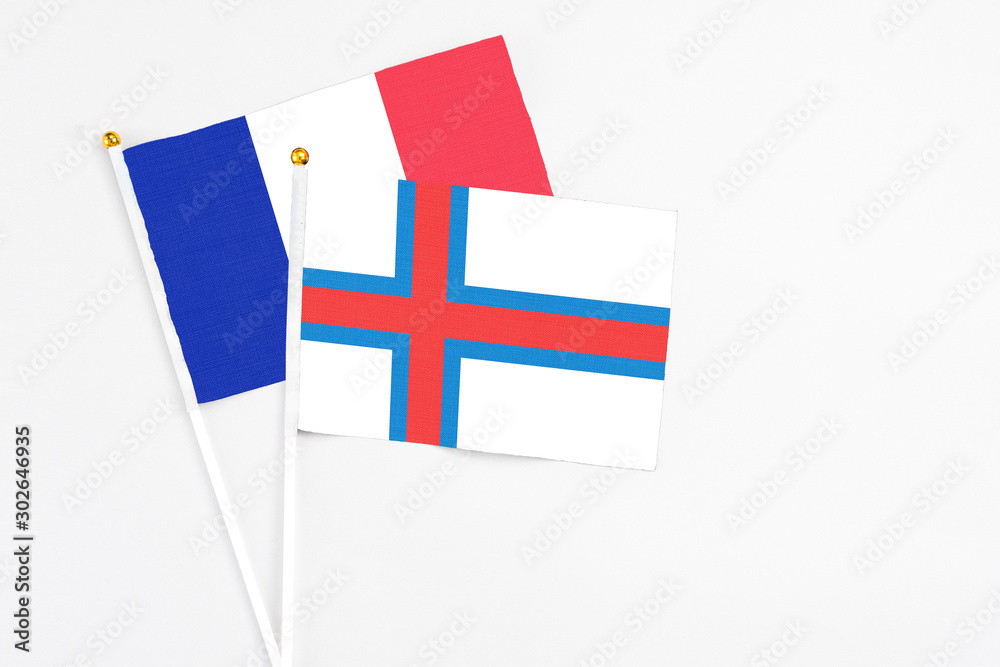 Faroe Islands and France stick flags on white background. High quality fabric, miniature national flag. Peaceful global concept.White floor for copy space.