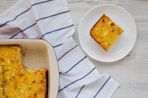 Homemade Cheesy Amish Breakfast Casserole on a white wooden background, top view. Flat lay, overhead, from above.