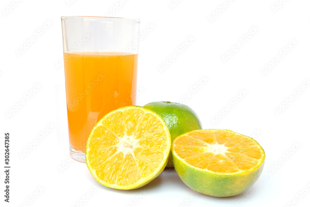 100% of fresh Orange juice in glass with Green oranges and sliced i 100% of fresh Orange juice in glass with Green oranges and sliced i