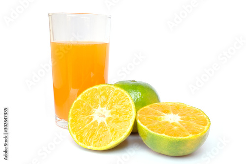 100% of fresh Orange juice in glass with Green oranges and sliced i
