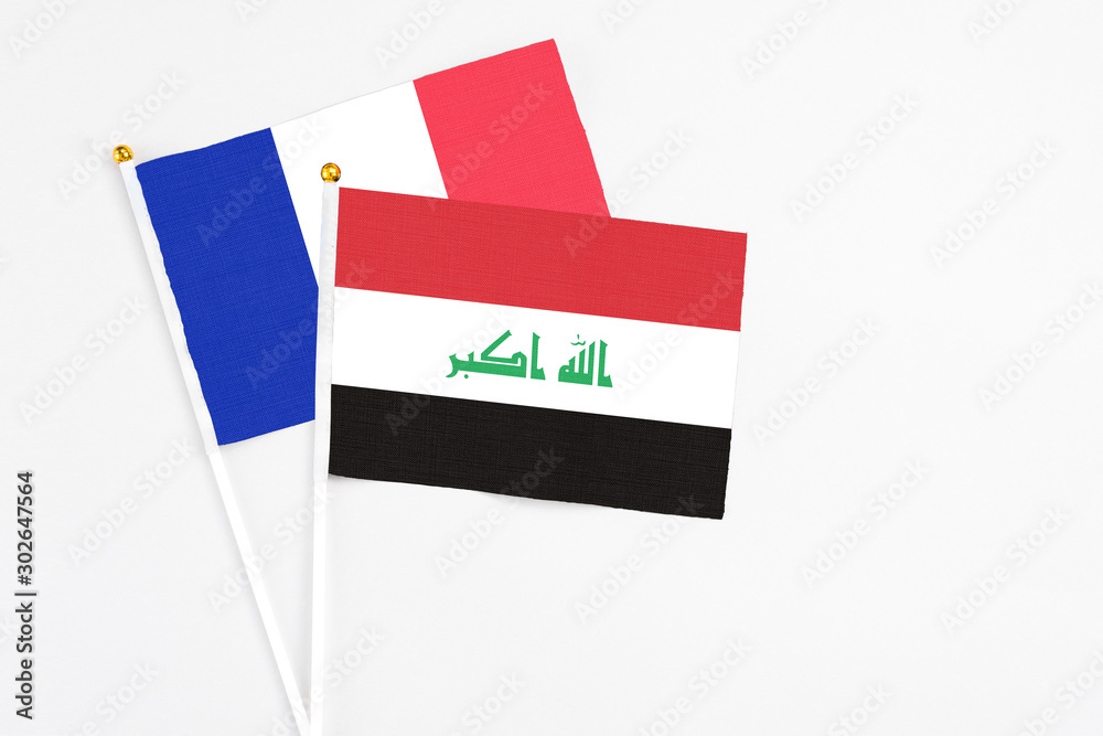 Iraq and France stick flags on white background. High quality fabric, miniature national flag. Peaceful global concept.White floor for copy space. Iraq and France stick flags on white background. High quality fabric, miniature national flag. Peaceful global concept.White floor for copy space.