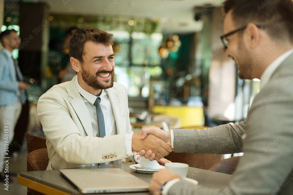 Fototapeta premium Businessmen shaking hands after meeting in a cafe