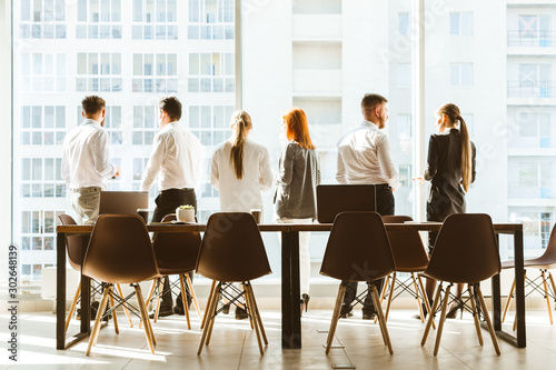 A team of young businessmen working and communicating together in an office. Corporate businessteam and manager in a meeting.