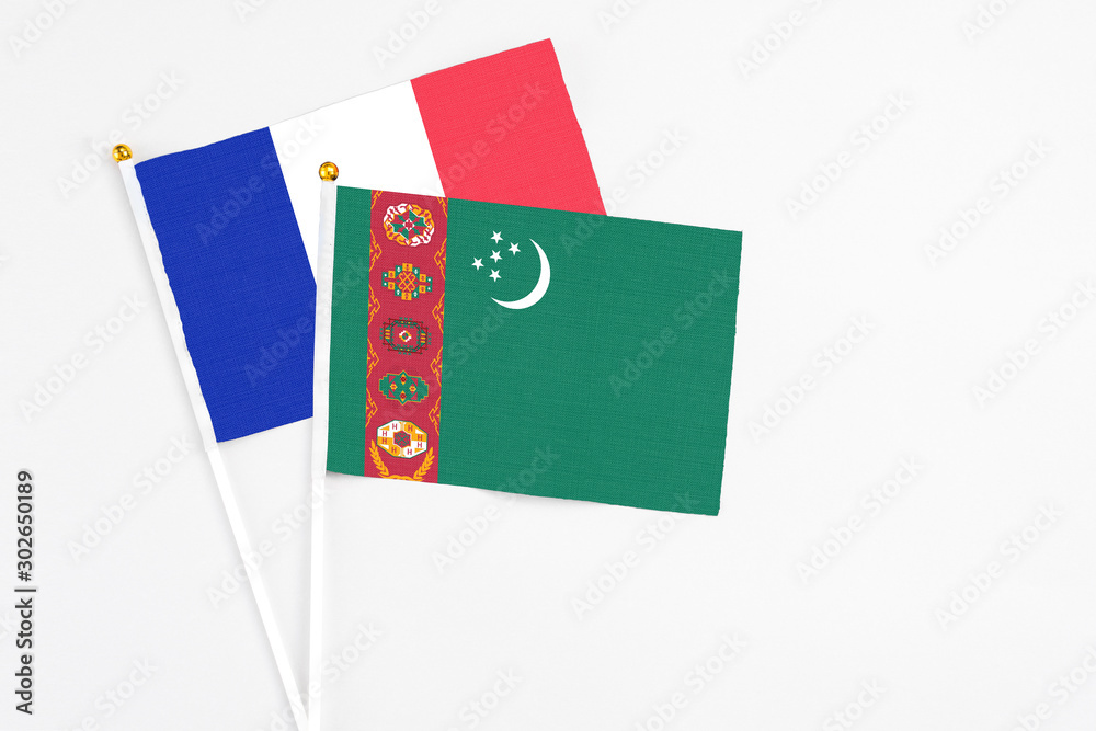 Turkmenistan and France stick flags on white background. High quality fabric, miniature national flag. Peaceful global concept.White floor for copy space. Turkmenistan and France stick flags on white background. High quality fabric, miniature national flag. Peaceful global concept.White floor for copy space.