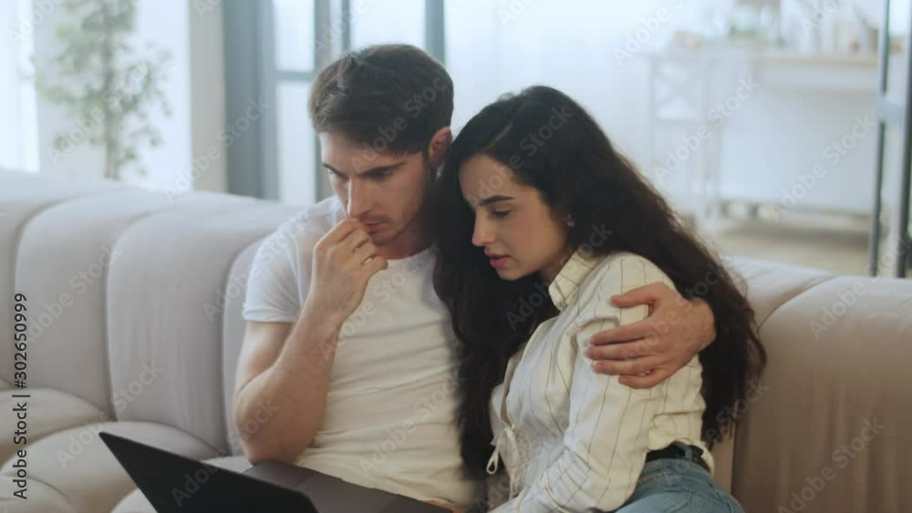 Young couple watching laptop computer at home in slow motion Young couple watching laptop computer at home in slow motion