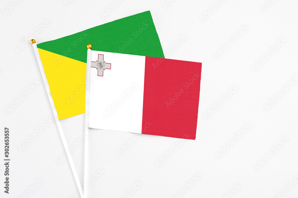 Malta and French Guiana stick flags on white background. High quality fabric, miniature national flag. Peaceful global concept.White floor for copy space. Malta and French Guiana stick flags on white background. High quality fabric, miniature national flag. Peaceful global concept.White floor for copy space.