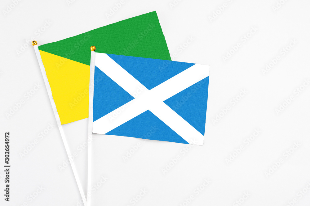 Scotland and French Guiana stick flags on white background. High quality fabric, miniature national flag. Peaceful global concept.White floor for copy space. Scotland and French Guiana stick flags on white background. High quality fabric, miniature national flag. Peaceful global concept.White floor for copy space.