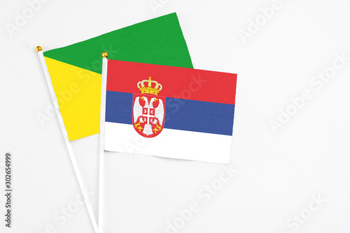 Free Download Serbia and French Guiana stick flags on white background. High quality fabric, miniature national flag. Peaceful global concept.White floor for copy space. - GFXLoad