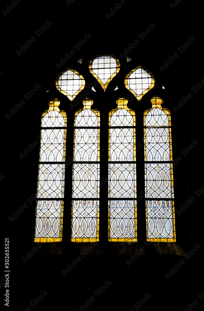 detailed view of a stained glass window in the historic church of Saint Ronan in Locronan in Brittany