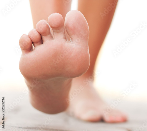 pies de mujer andando descalza con fondo blanco