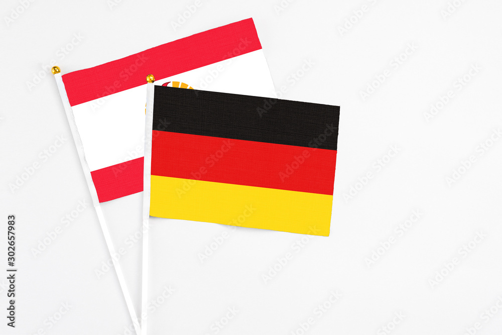 Germany and French Polynesia stick flags on white background. High quality fabric, miniature national flag. Peaceful global concept.White floor for copy space. Germany and French Polynesia stick flags on white background. High quality fabric, miniature national flag. Peaceful global concept.White floor for copy space.