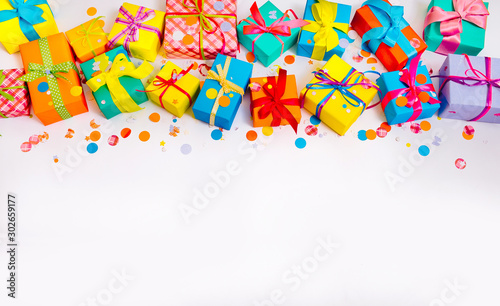 Fototapeta Naklejka Na Ścianę i Meble -  Gift wrapped in paper. Small gifts are packed in colored paper. Colored ribbons. Gift wrapping. White background. View from above. Pastel shades