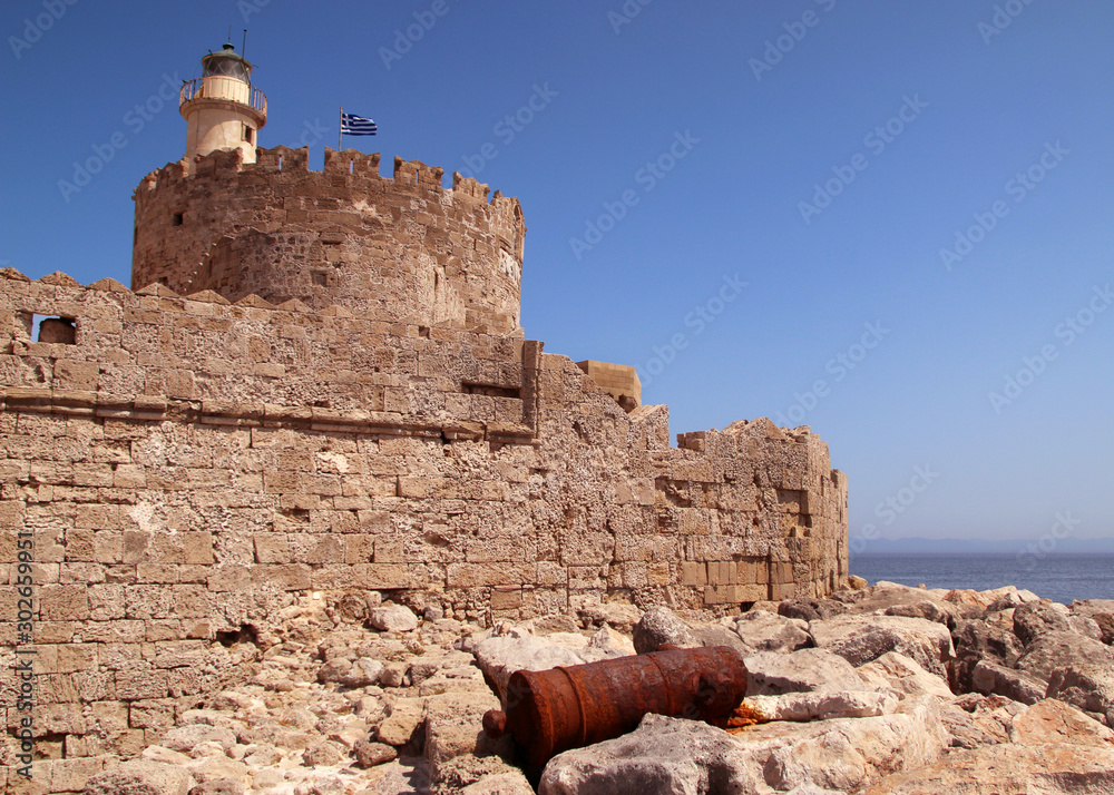 Fort of Saint Nicholas and old rusty cannon near its walls, Mandraki Harbour, Rhodes, Greece