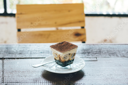 Banoffee pie on wooden table with blurred chair behind. photo