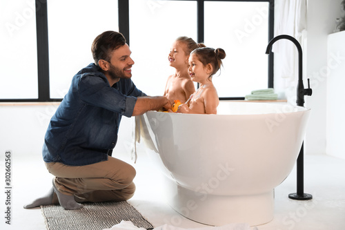 Young father with little daughters in bathroom