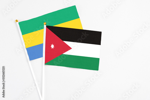 Jordan and Gabon stick flags on white background. High quality fabric, miniature national flag. Peaceful global concept.White floor for copy space.