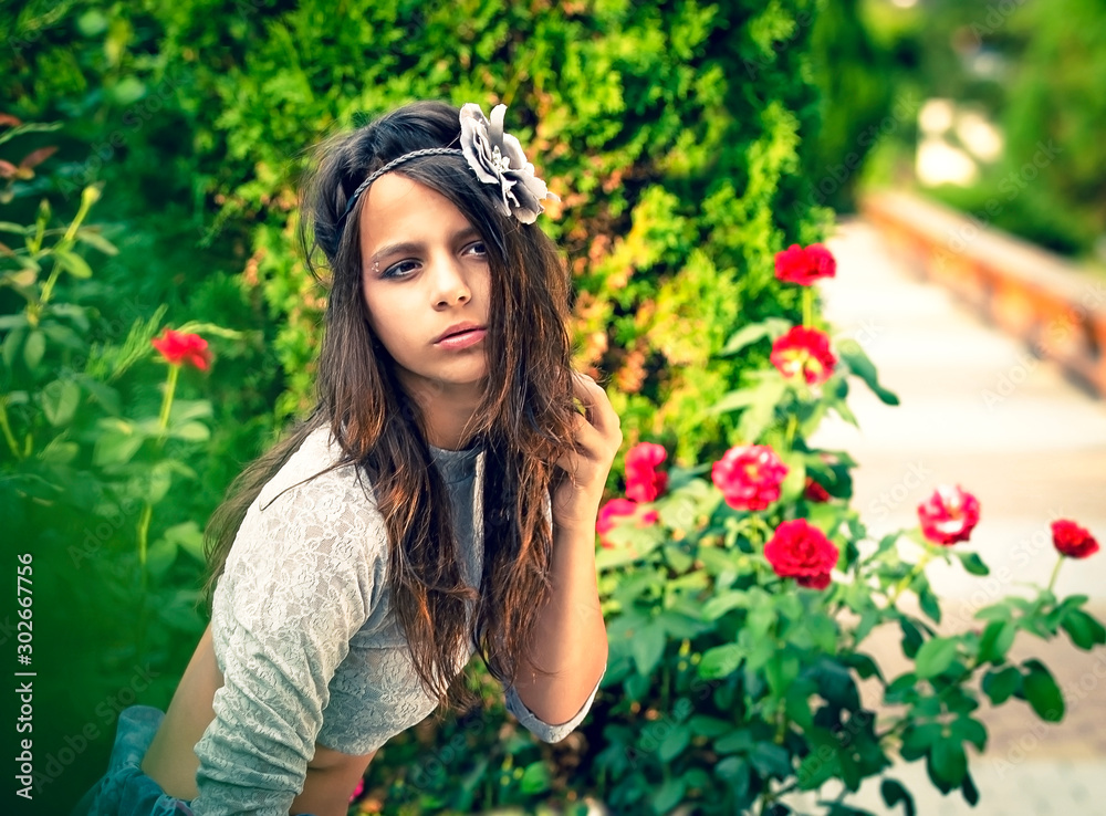Portrait of beautiful cute brunette teenager model with makeup, poreo posing on the sea coast. young girl in a delicate turtleneck and a rim in the form of a flower against a background of greenery Portrait of beautiful cute brunette teenager model with makeup, poreo posing on the sea coast. young girl in a delicate turtleneck and a rim in the form of a flower against a background of greenery