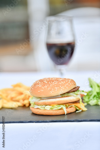 A burger with fries and a cold coke