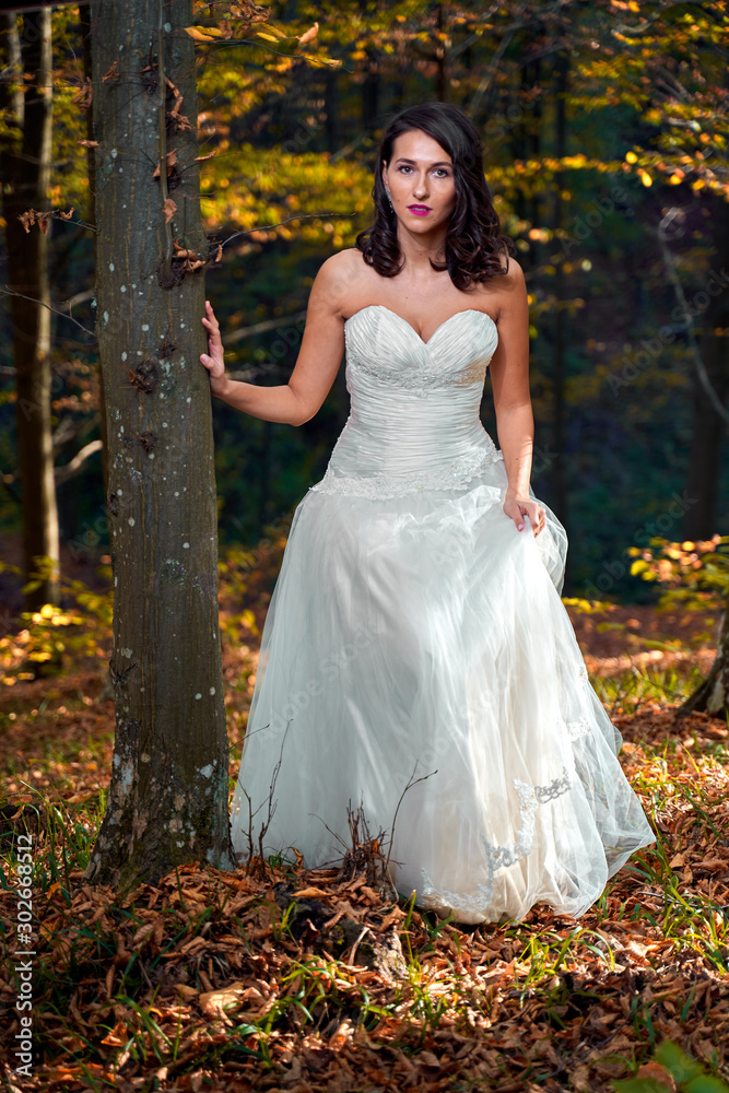 Bride in white dress in the forest