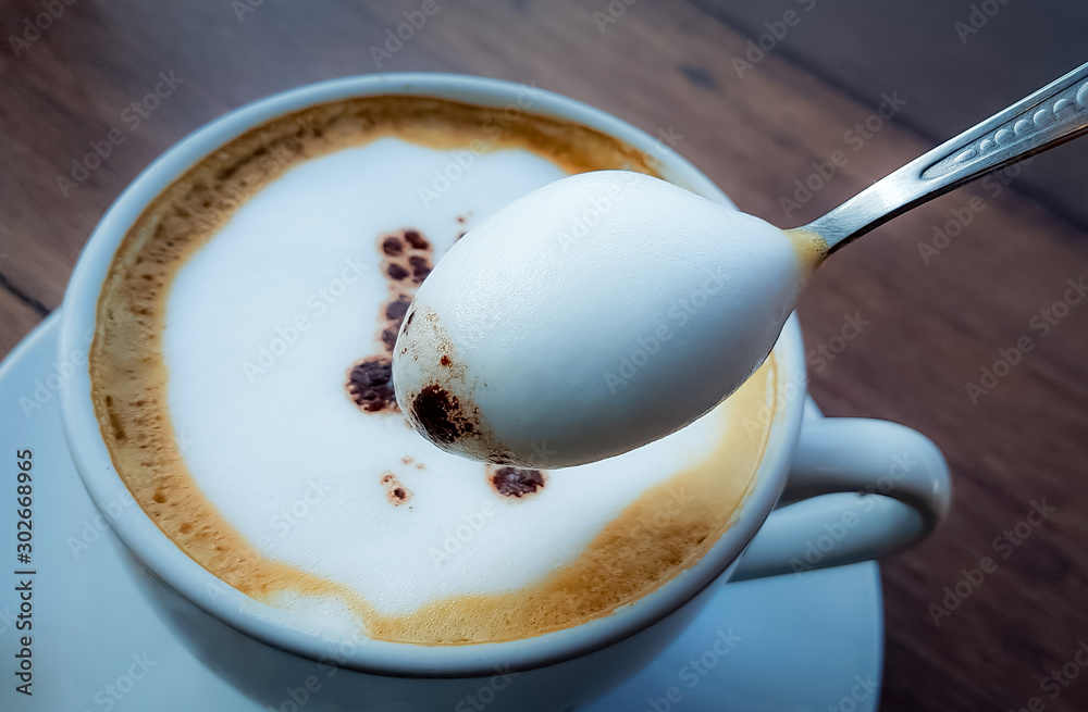 Blurred images of ready-to-drink cappuccino cups placed on a wooden table in the morning as background images and beautiful illustrations Blurred images of ready-to-drink cappuccino cups placed on a wooden table in the morning as background images and beautiful illustrations