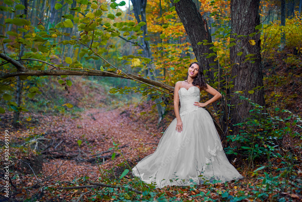 Bride in white dress in the forest