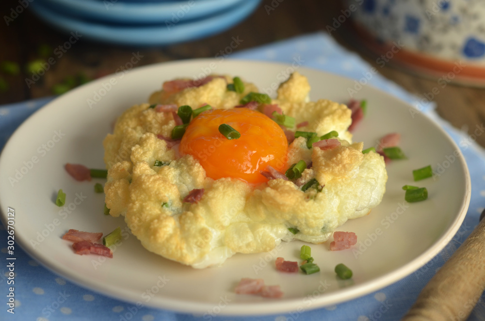 Baked egg with bacon and chives on a plate