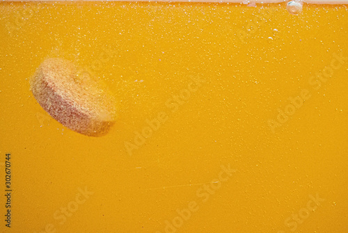 dissolving effervescent tablet in a water, antacid table with gas bubble texture. photo