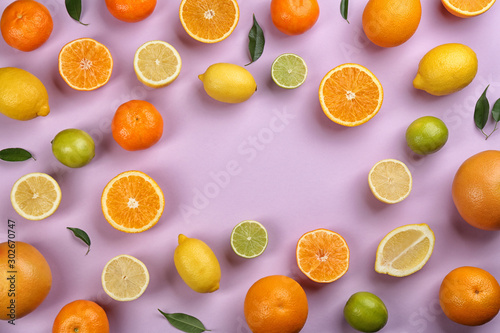 Flat lay composition with tangerines and different citrus fruits on lilac background. Space for text