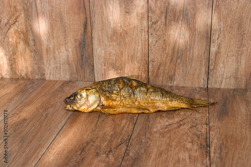 Hot smoked carp on old wooden boards.