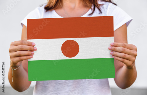 woman holds flag of Niger on paper sheet